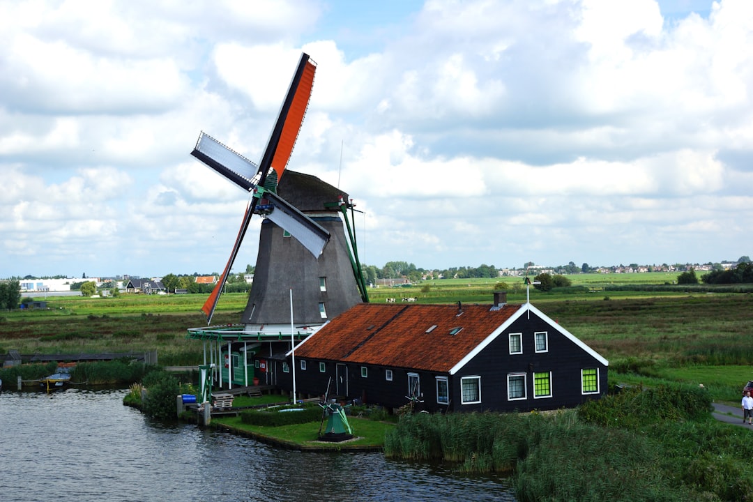 A windmill sitting next to a body of water
